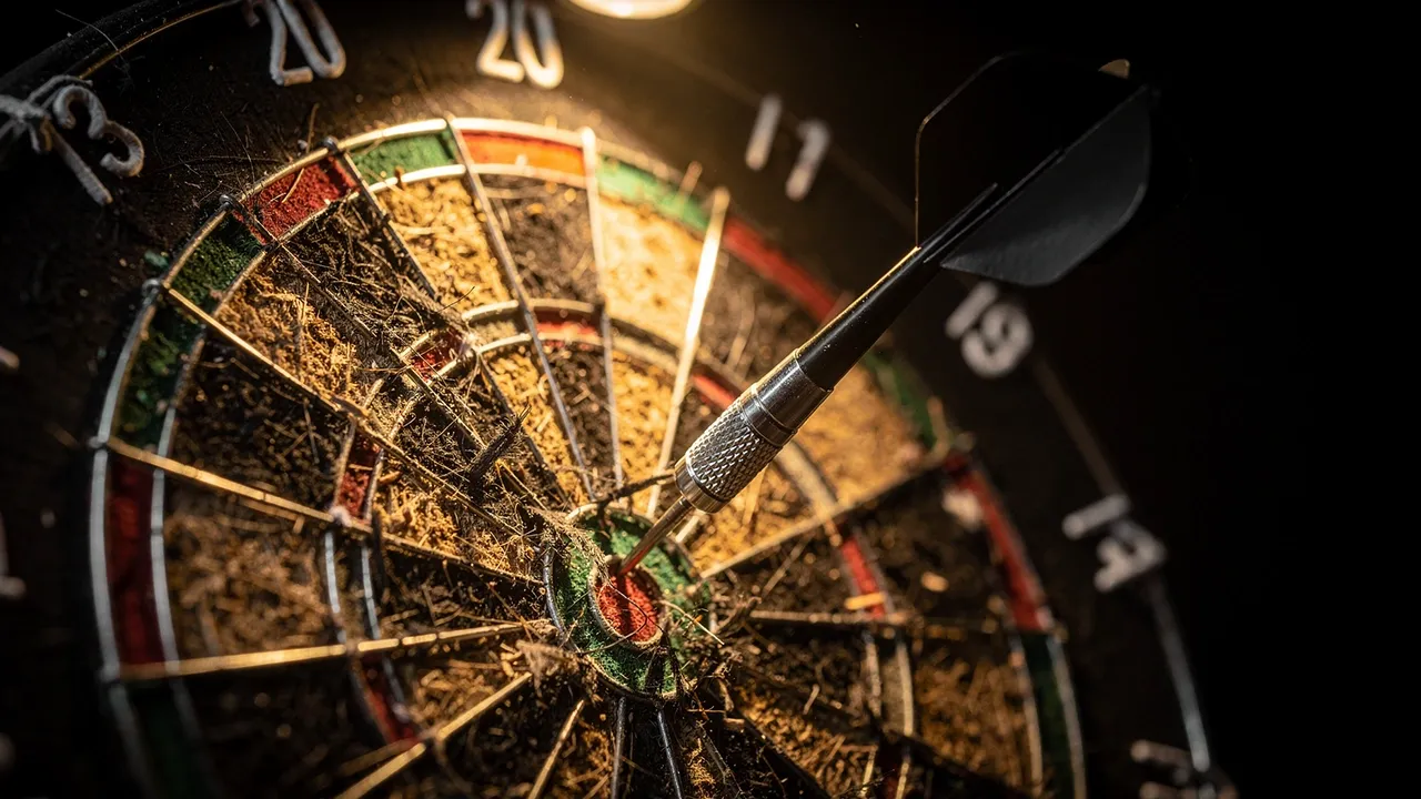 Dartpfeil steckt im Triple-20-Feld einer Dartscheibe auf der WM-Bühne
